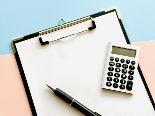 バインダーと電卓で価格や疑問のイメージ